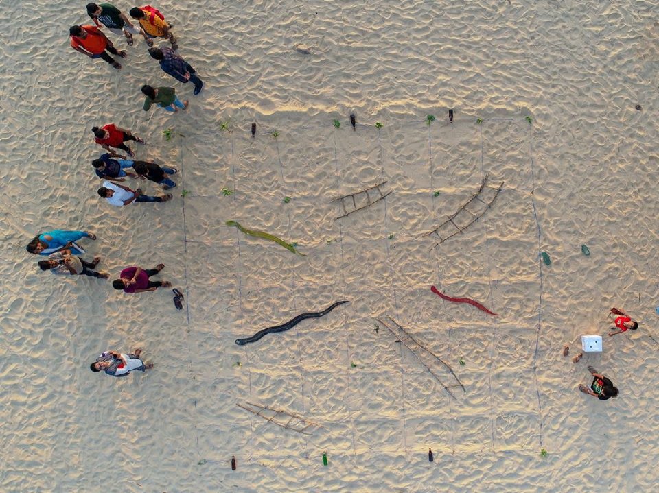 Students playing a giant beach game on the sands